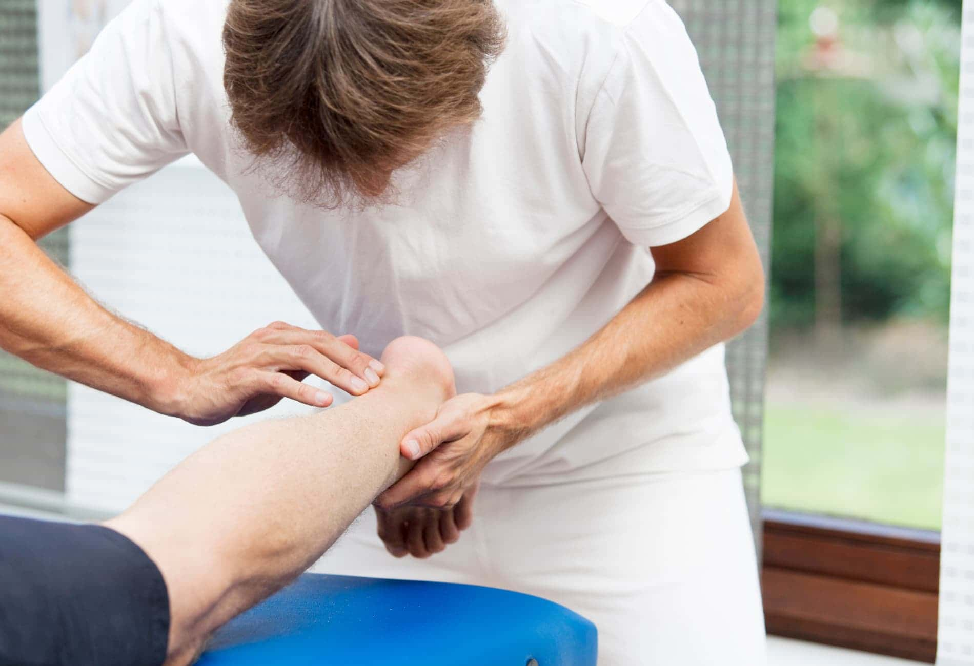 "Fisioterapeuta ajudando paciente com exercícios de alongamento para aliviar a Síndrome de Haglund."